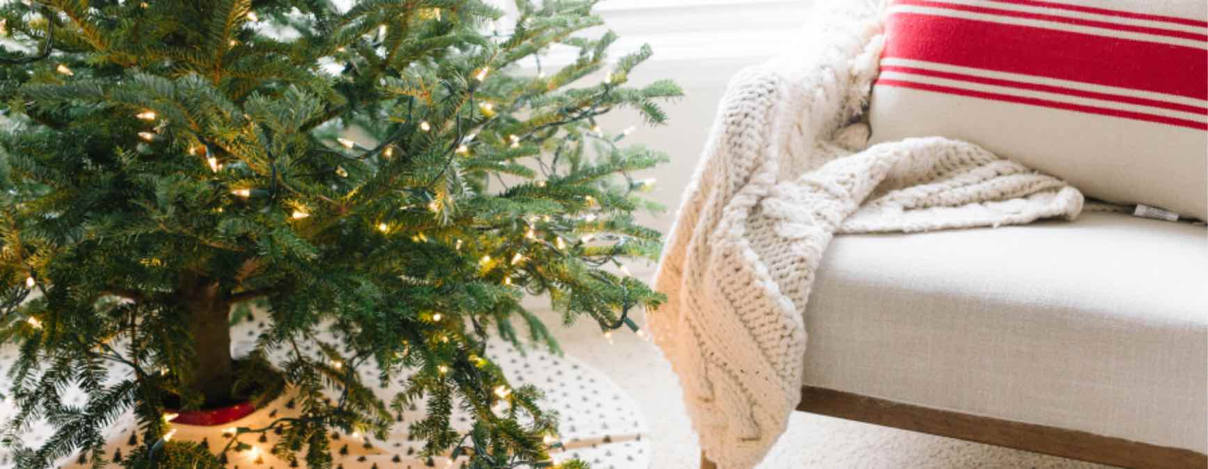 A cozy chair and blanket by the Christmas tree that is clean and welcoming thanks to Zerorez Calgary.