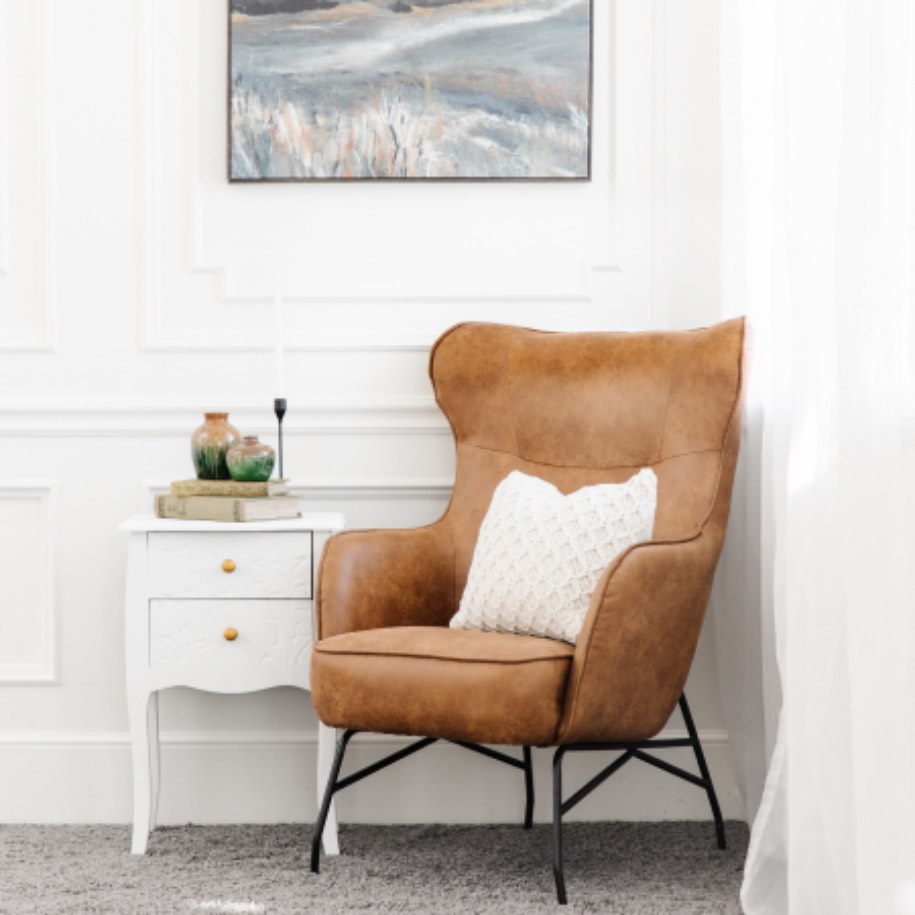 Clean, orange leather chair with small dresser with Zerorez Calgary.